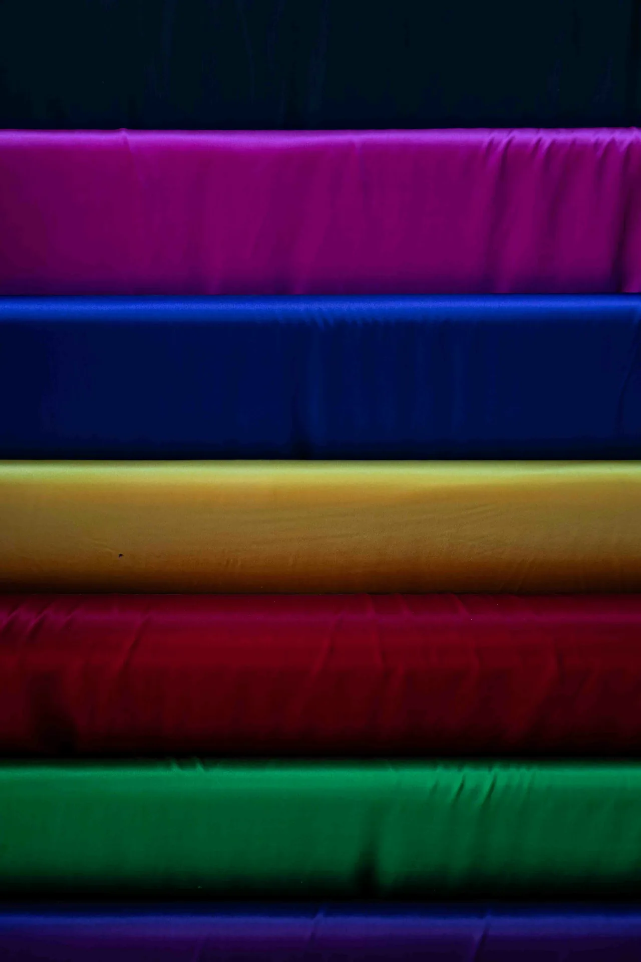 Stacked rolls of colorful fabric